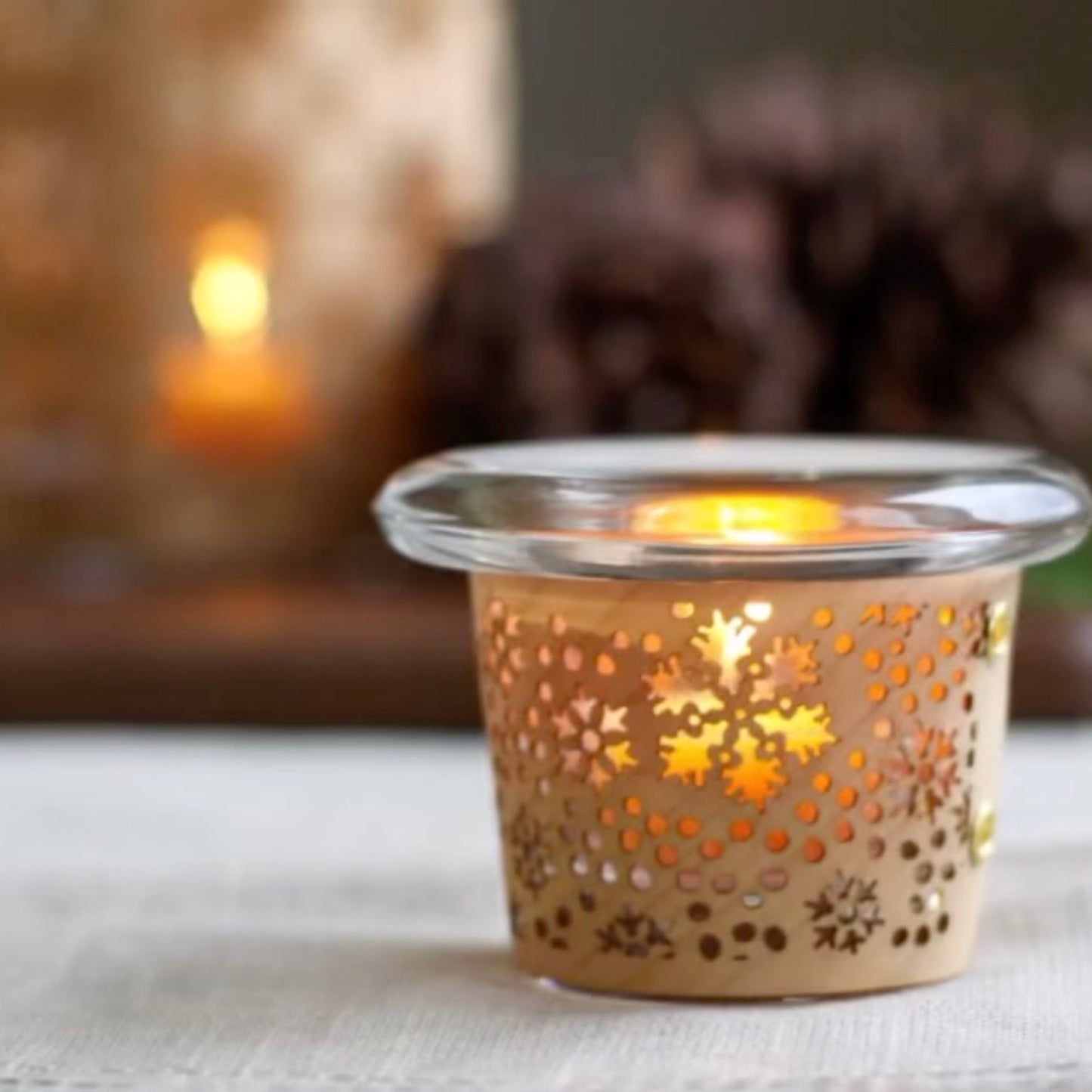 a tea light holder with a snowflake design handmade in maple and glass