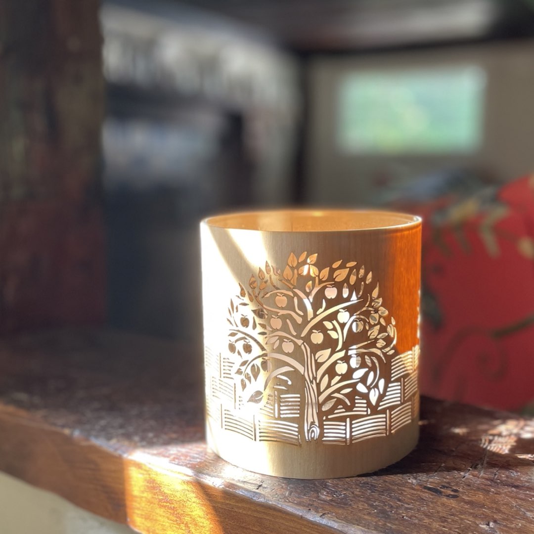 A candle holder or lantern with an apple orchard design iinspired by kelmscott manor