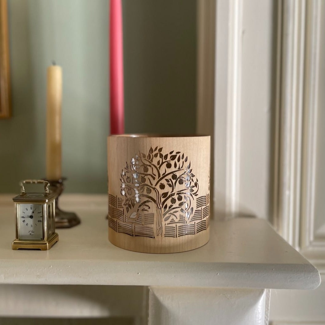 A candle holder or lantern with an apple  orchard design iinspired by kelmscott manor
