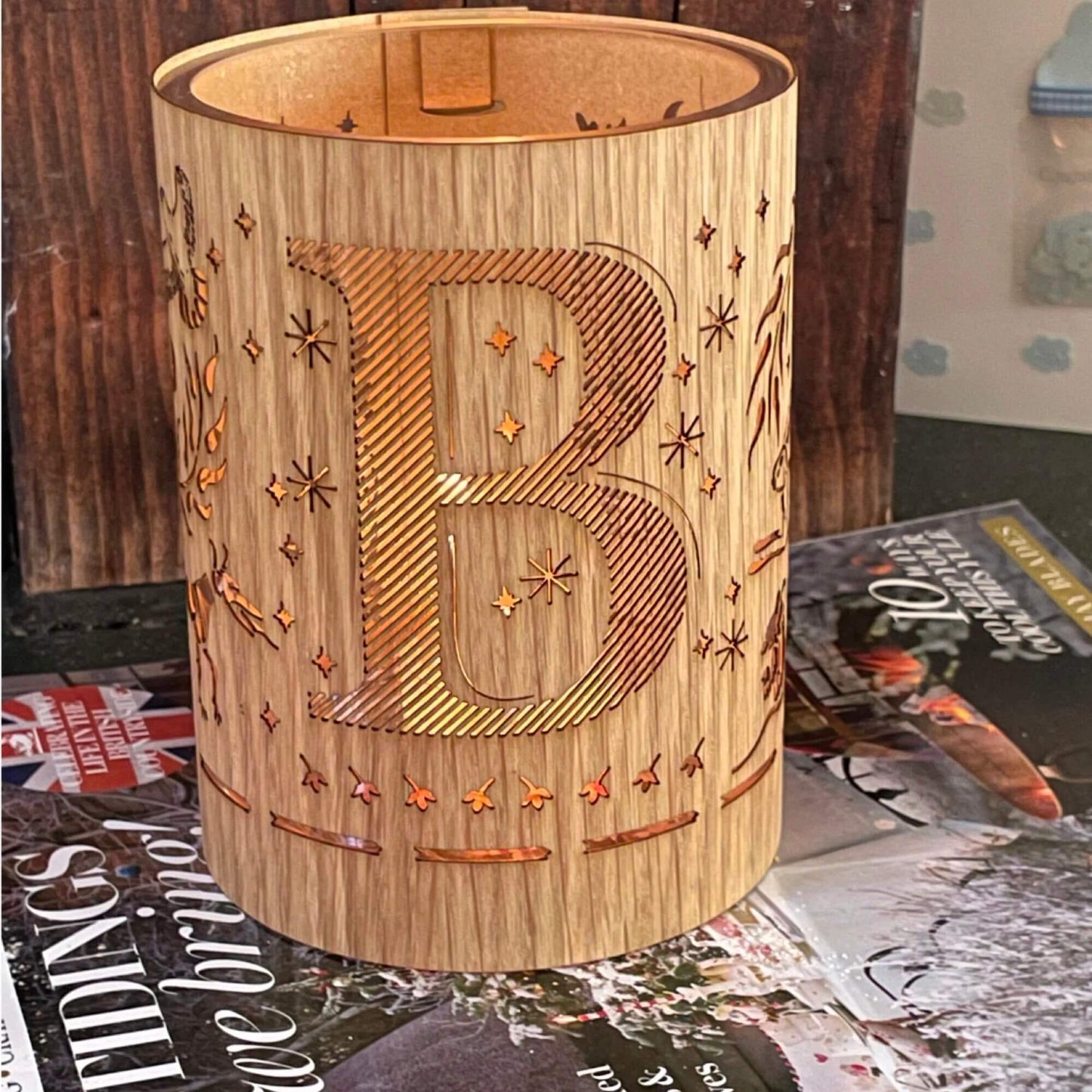 A wood and glass lantern monogrammed with the letter B