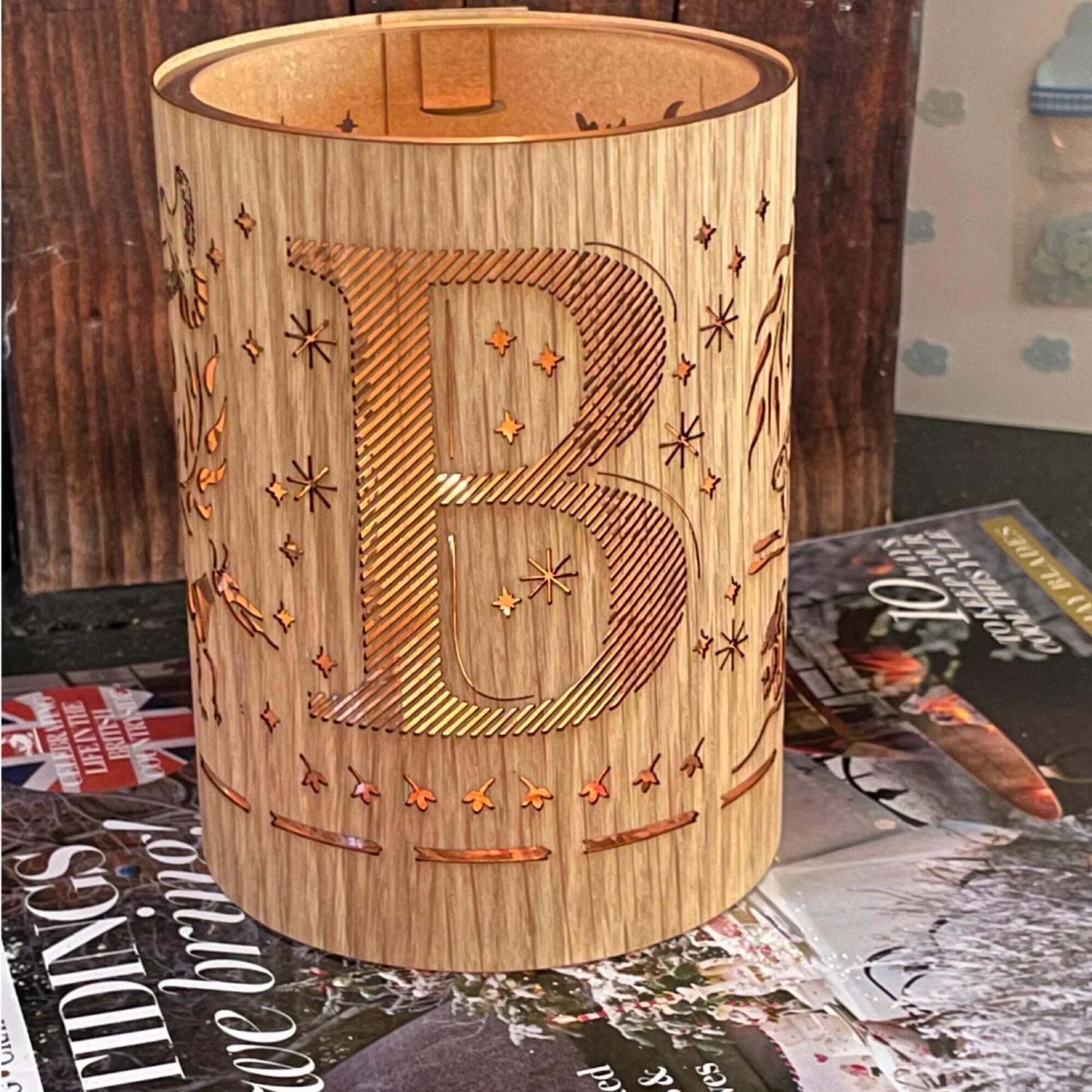 A wood and glass lantern monogrammed with the letter B
