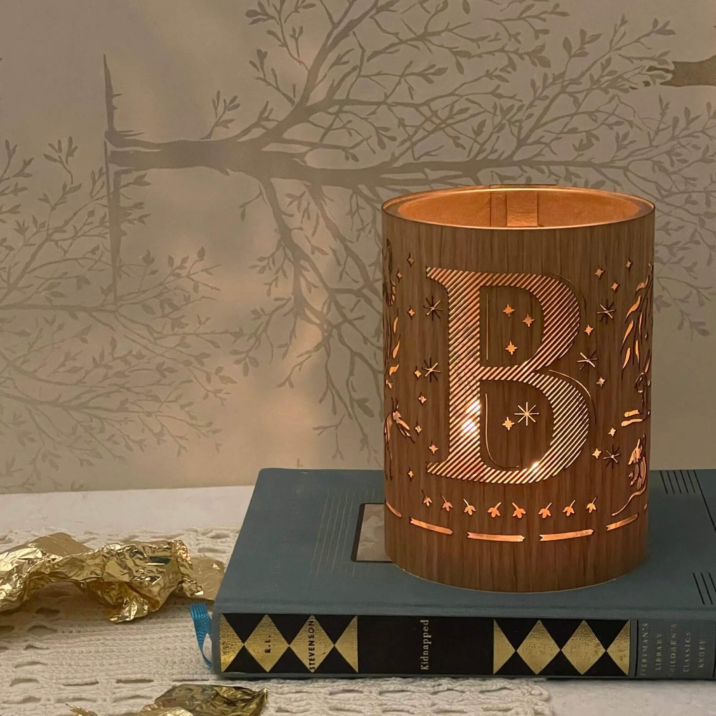 A wood and glass lantern monogrammed with the letter B