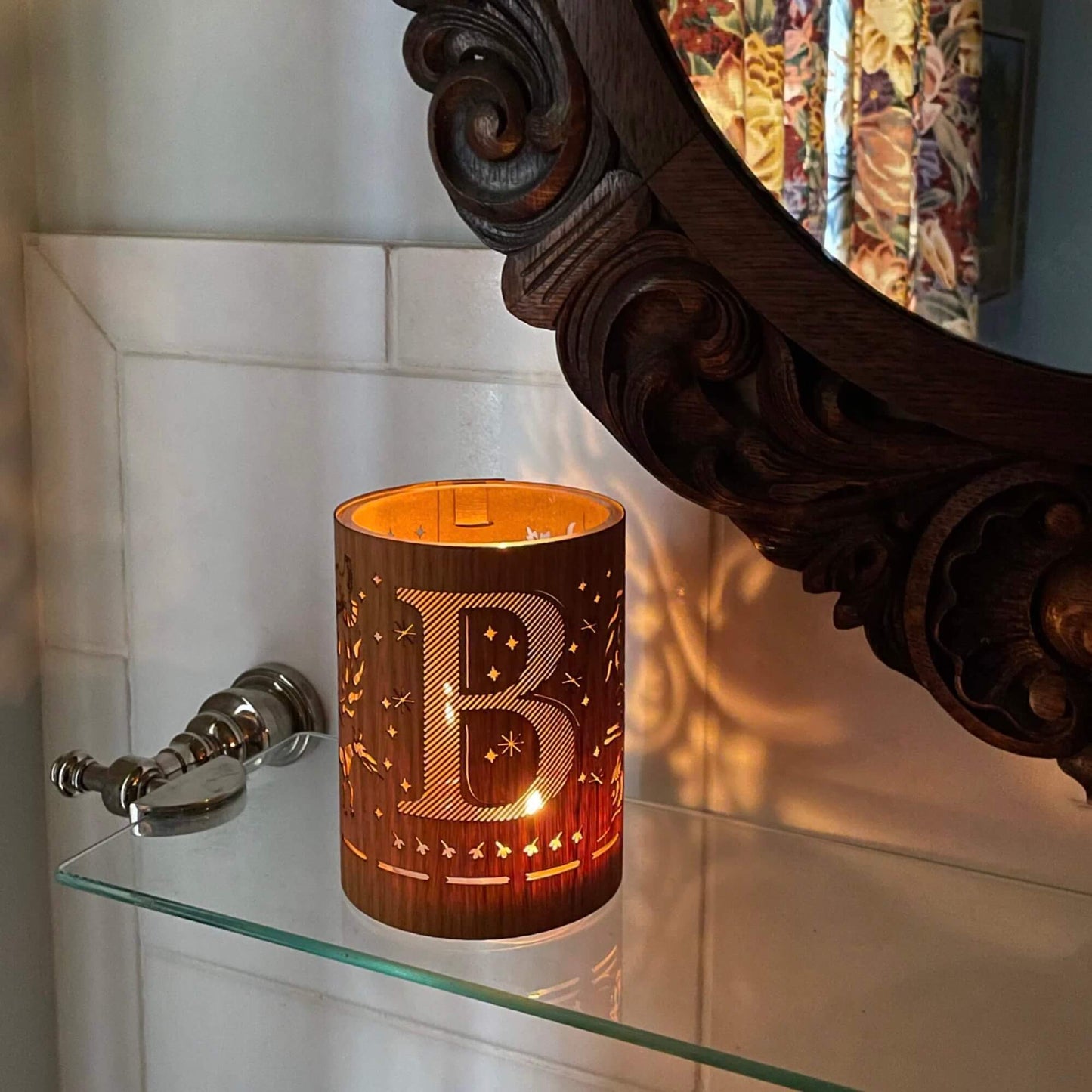 A wood and glass lantern monogrammed with the letter B