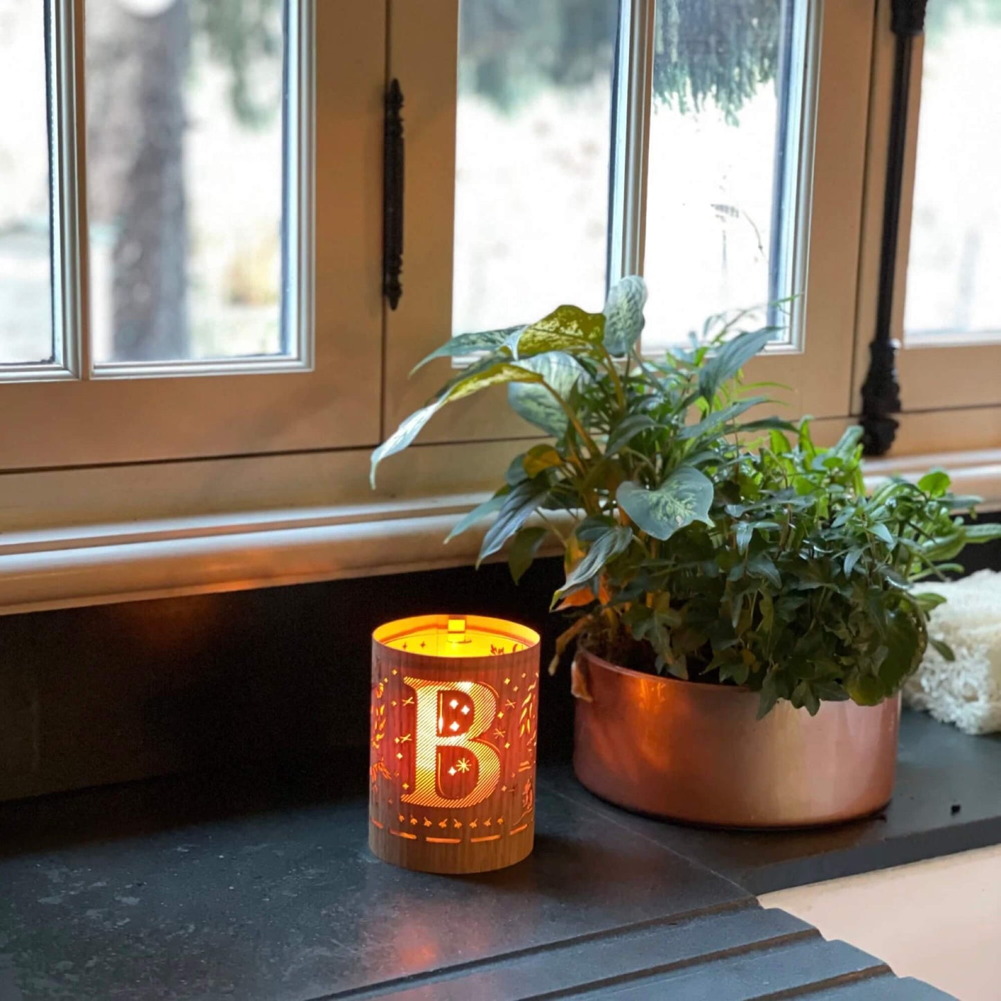 A wood and glass lantern monogrammed with the letter B
