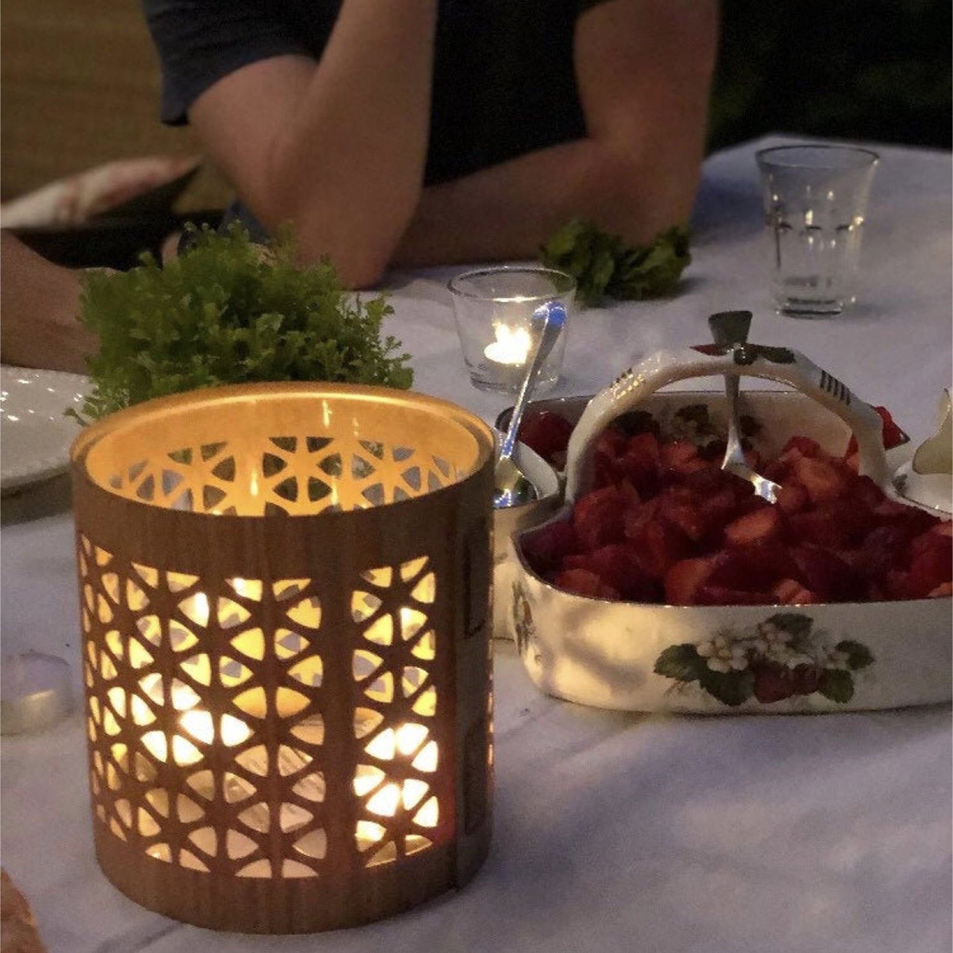 A mid century modern lantern, size medium White Oak, in the evening at dinner