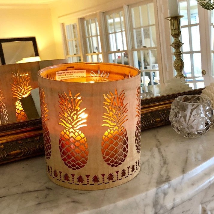 A gorgeous picture of the pineapple lantern in maple on a marble mantle