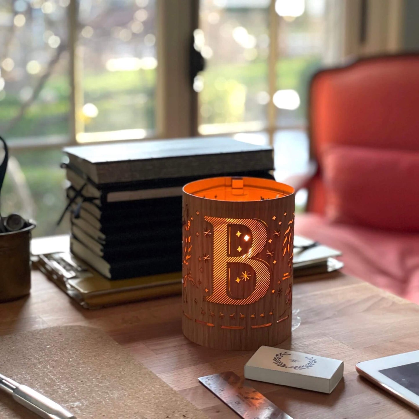 A wood and glass lantern monogrammed with the letter B 