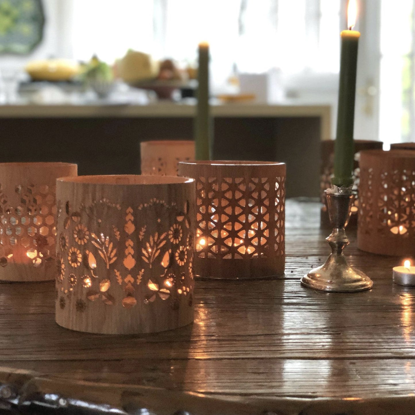 a selection of lanterns on a wood table the medium floral lantern in the foreground