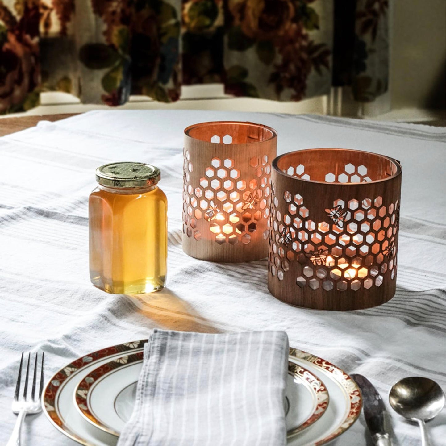 small maple honeybee lantern beside a medium Black Walnut lantern on the table beside a jar of honey  Edit alt text