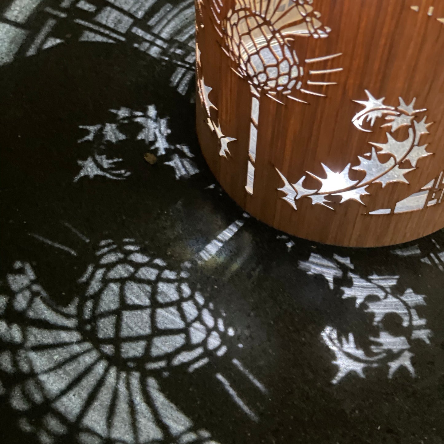 a white oak thistle design lantern on the slate counter top below the pendant light