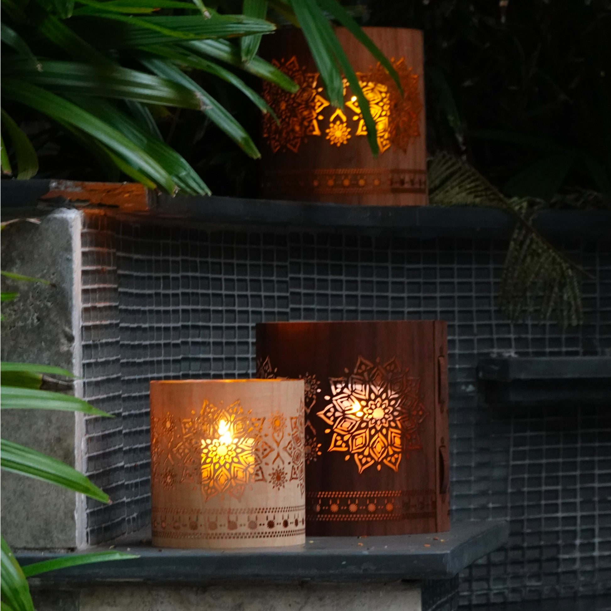 medium maple mandala lantern with a large walnut mandala lantern and a large maple mandala lantern on the ledge of a pool in the garden of a home in Key West Florida  Edit alt text