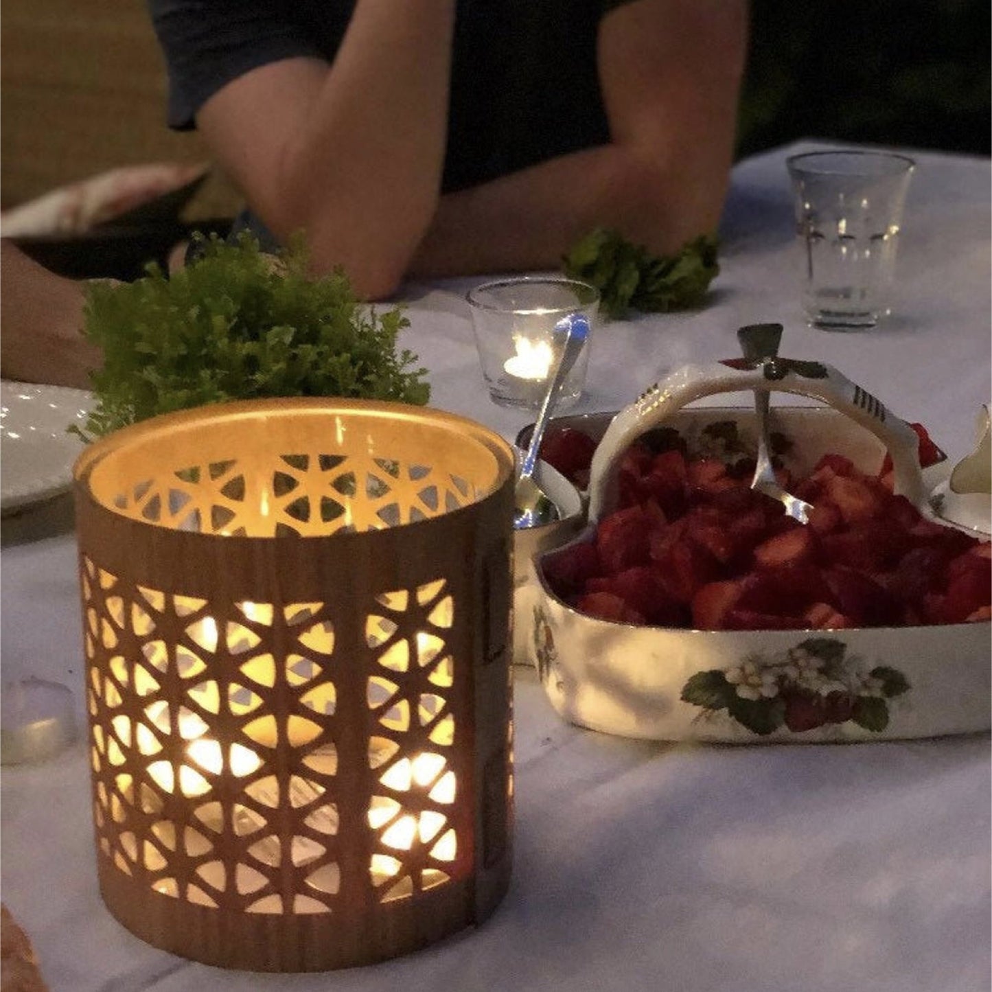 A mid century modern lantern, size medium white oak, in the evening at dinner