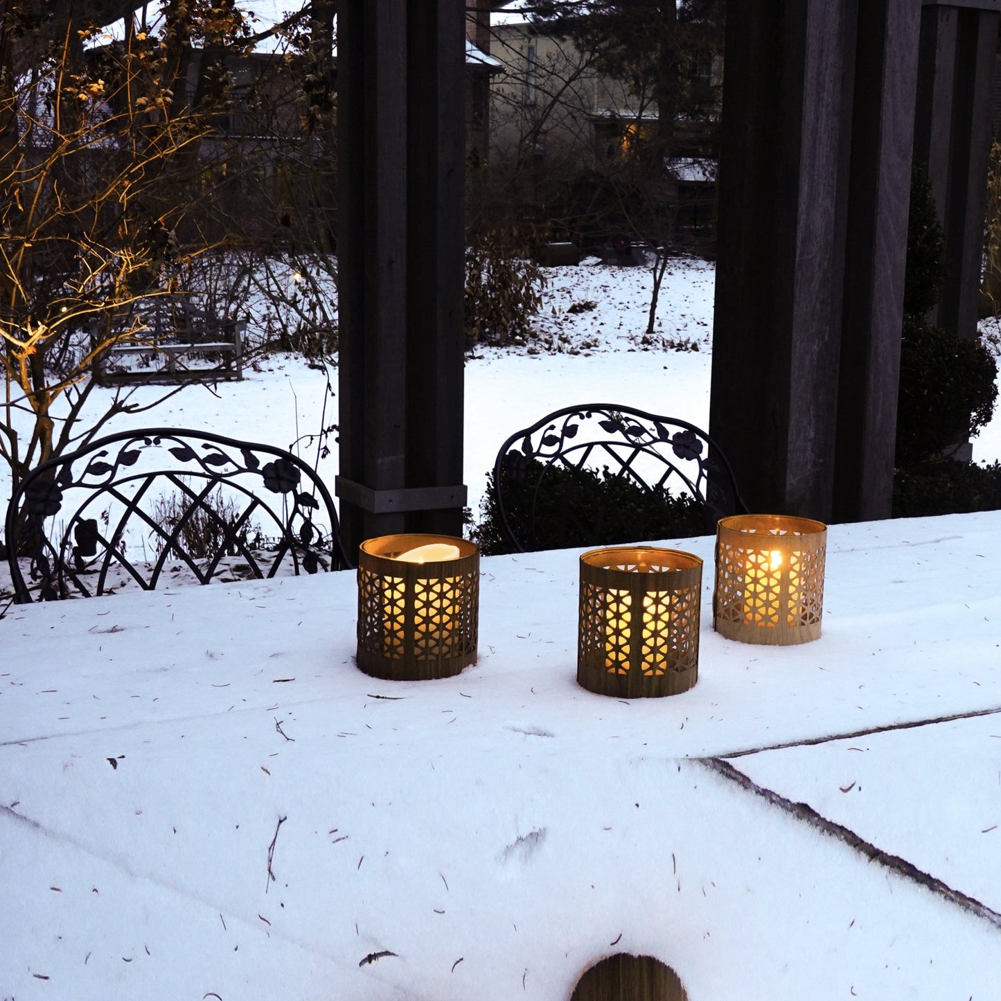 Three mid century modern lanterns in size medium in black walnut, white oak and maple in a table covered with a dusting of snow