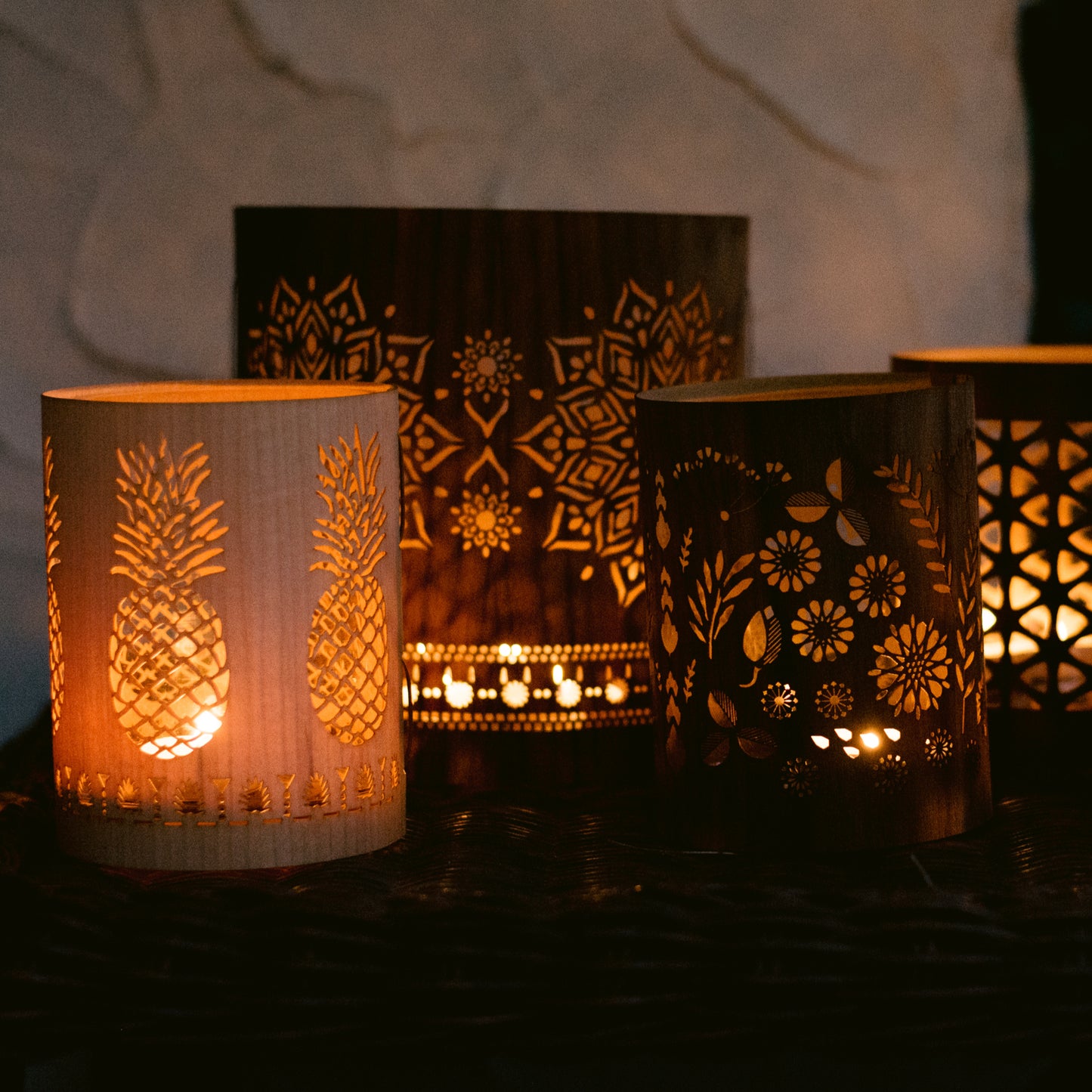 a small maple pineapple lantern in front of a large mandala and beside a Fleur lantern size small